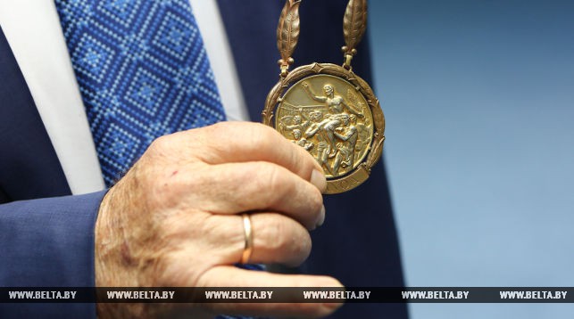 Олимпийский чемпион по гребле на байдарках и каноэ Сергей Макаренко показывает свою медаль