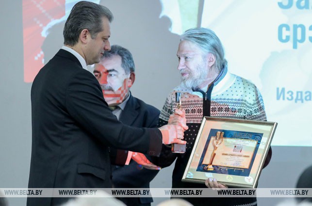 Заместитель министра информации Игорь Бузовский вручает приз победителю в номинации "Вместе с книгой мы растем"