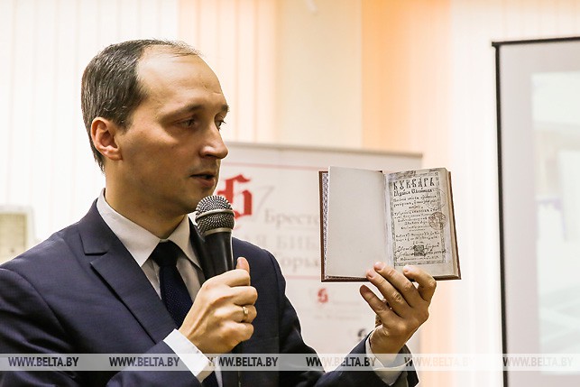 Заместитель директора Национальной библиотеки Беларуси Александр Суша держит в руках факсимильное издание "Букварь"