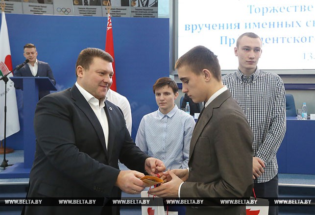 Дмитрий Лукашенко вручает свидетельство Александру Родионову.