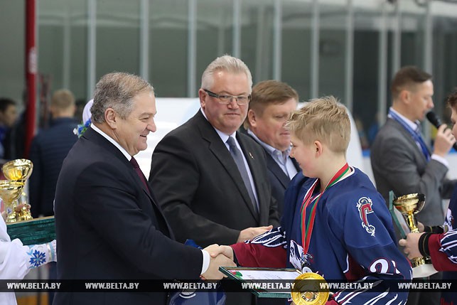 Председатель Федерации хоккея Беларуси Семен Шапиро вручает награду за второе место "Грифонам".