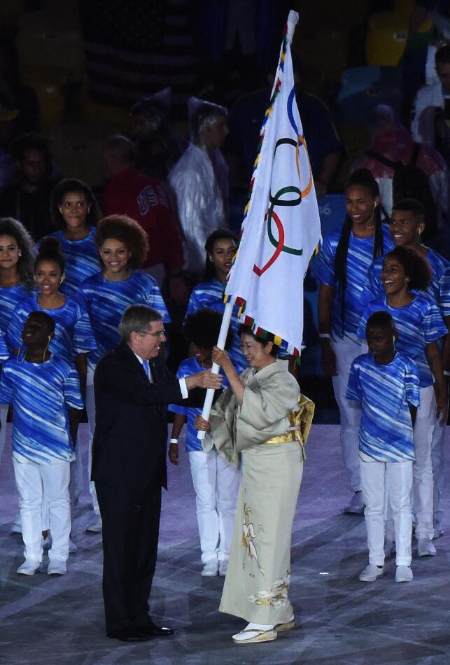 Церемония закрытия Олимпиады. Президент Международного олимпийского комитета Томас Бах передает олимпийский флаг губернатору Токио Юрико Коикэ. Фото СИНЬХУА-БЕЛТА