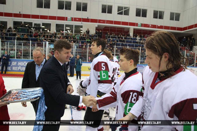 Заместитель министра спорта и туризма Беларуси Александр Барауля награждает команду Латвии.