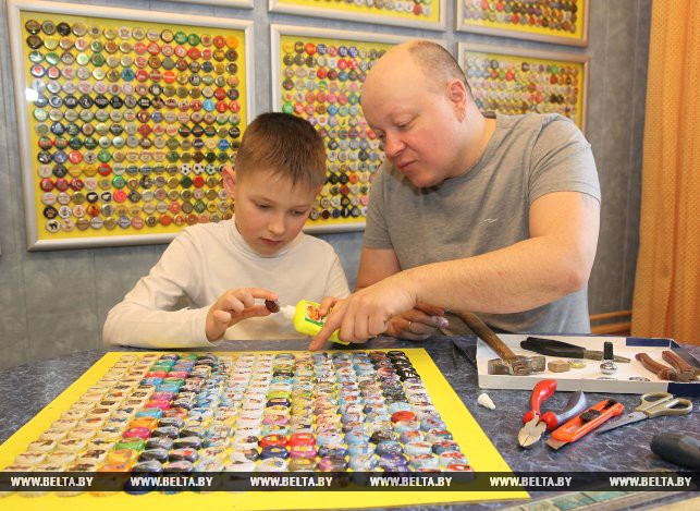 Антон Козлов с сыном Георгием за оформлением коллекции пробок