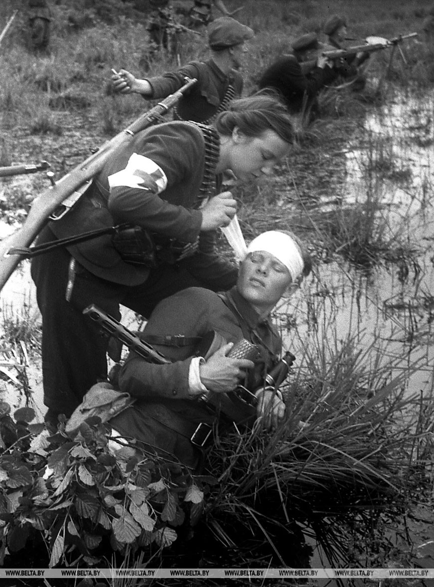 Пинские болота. Медсестра Н.К.Федюшова оказывает медицинскую помощь командиру отряда имени Кирова И.М.Курбану, июнь 1943 года