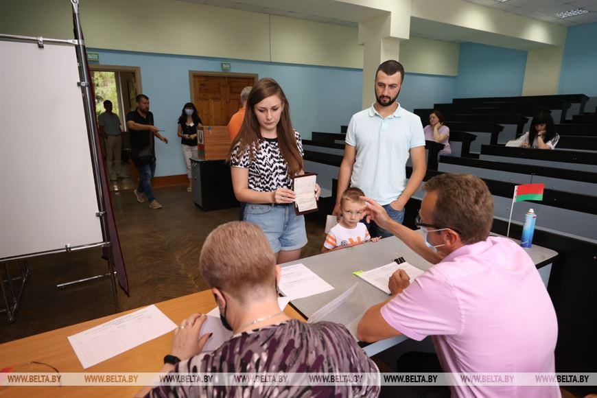 Александр и Анастасия Лазовские с сыном Кириллом голосуют на участке для голосования