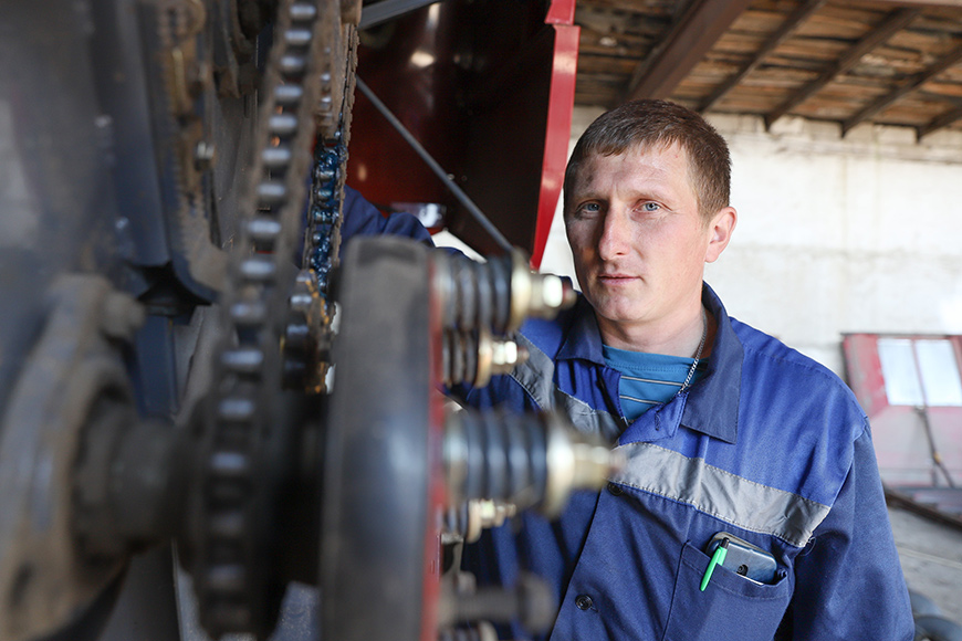 Механизатор Андрей Скоков занимается подготовкой своего зерноуборочного комбайна