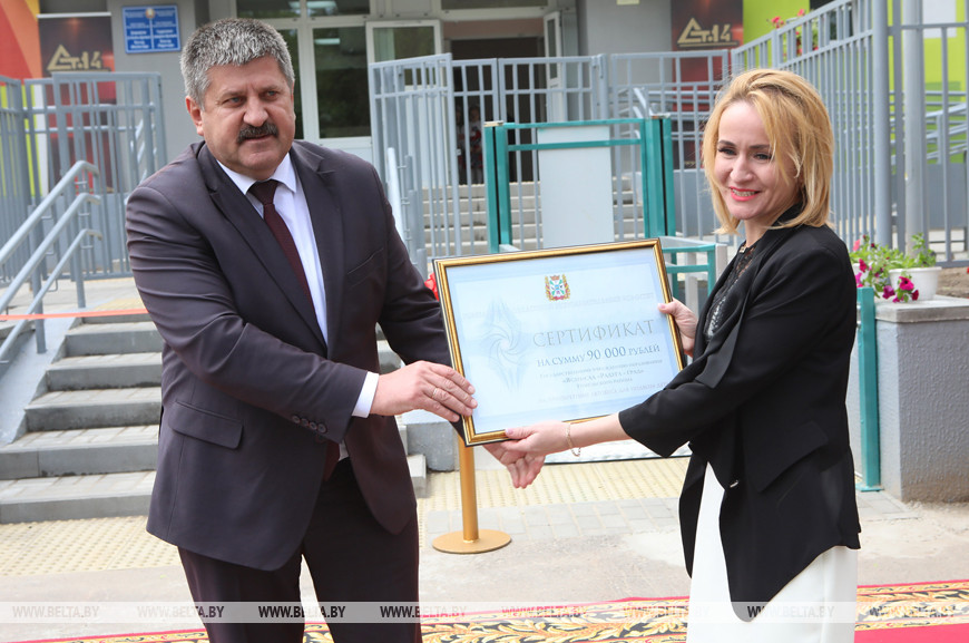 Председатель Гомельского облисполкома Геннадий Соловей вручает денежный сертификат заведующей яслями-садом Елене Дребенковой