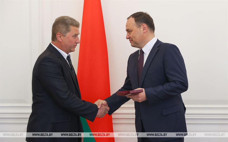 Роман Головченко вручает медаль "За трудовые заслуги" токарю-расточнику Владимиру Флейте