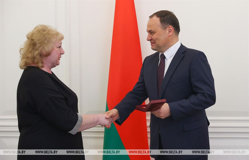 Роман Головченко вручает медаль "За трудовые заслуги" формовщику Надежде Кунцевич