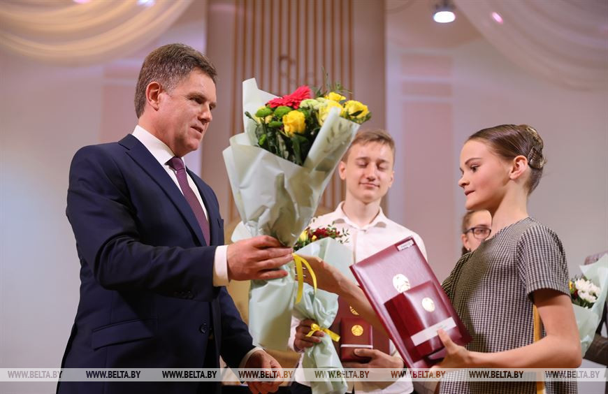 Игорь Петришенко вручает нагрудный знак Алисе Рощиной