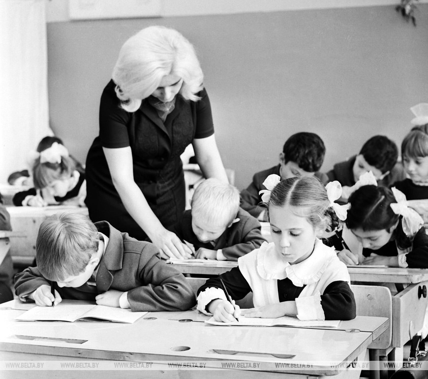 Педагог-воспитатель Л.М.Рухлевич помогает ученикам 1 "А" класса подготовиться к урокам, 1972 год Педагог-воспитатель Л.М.Рухлевич помогает ученикам 1 "А" класса подготовиться к урокам, 1972 год