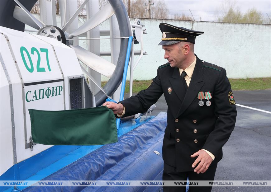 Командир плавучего средства Артем Шаповал снимает драпировку с борта судна Командир плавучего средства Артем Шаповал снимает драпировку с борта судна