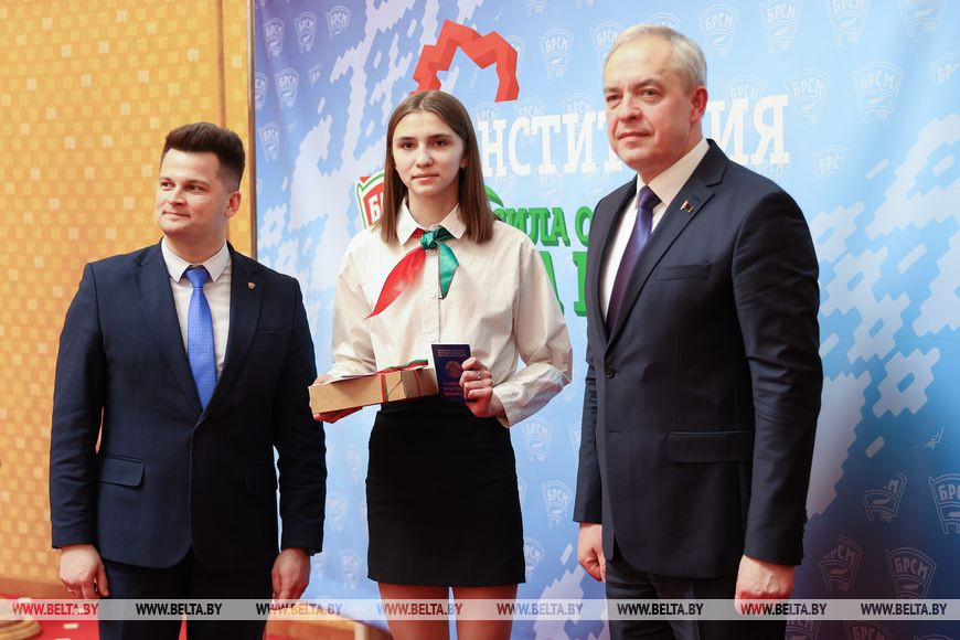 Глава Администрации Президента Республики Беларусь Игорь Сергеенко и первый секретарь Центрального комитета БРСМ Александр Лукьянов вручают паспорт гражданина Республики Беларусь Ангелине Курьянчик