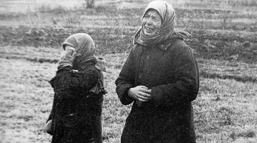 Женщина и девочка плачут, глядя на тело повешенного мужчины Женщина и девочка плачут, глядя на тело повешенного мужчины