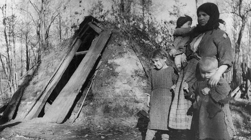 1942 год. Белоруска с детьми у входа в землянку 1942 год. Белоруска с детьми у входа в землянку